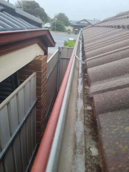 A clean gutter and downpipe on a brick home after cleaning