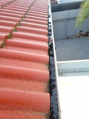 A clean gutter above a paved yard after cleaning